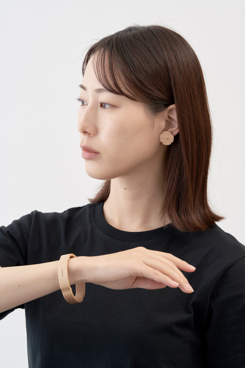 木瓜紋をモチーフにした18Kイエローゴールドの木製ピアスとバングル。