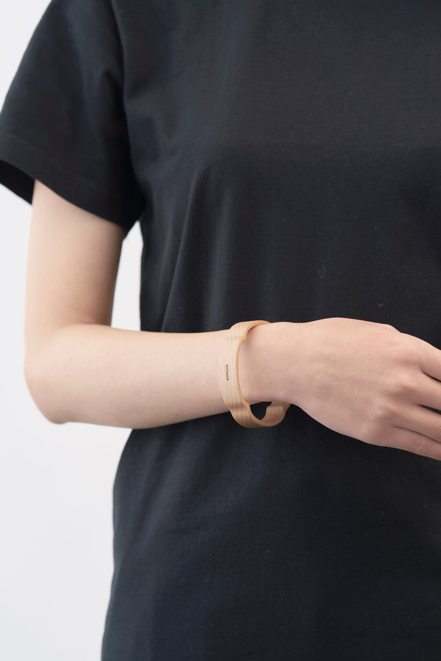 木瓜紋をモチーフにした木製バングルをしたモデル。