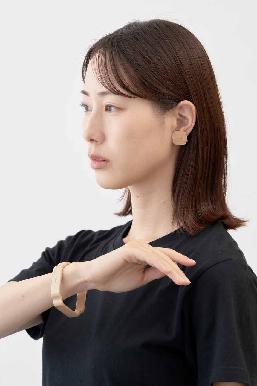 木瓜紋をモチーフにした18Kイエローゴールドの木製ピアスとバングル。