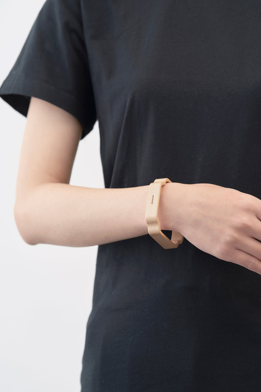 木瓜紋をモチーフにした木製バングルをしたモデル。