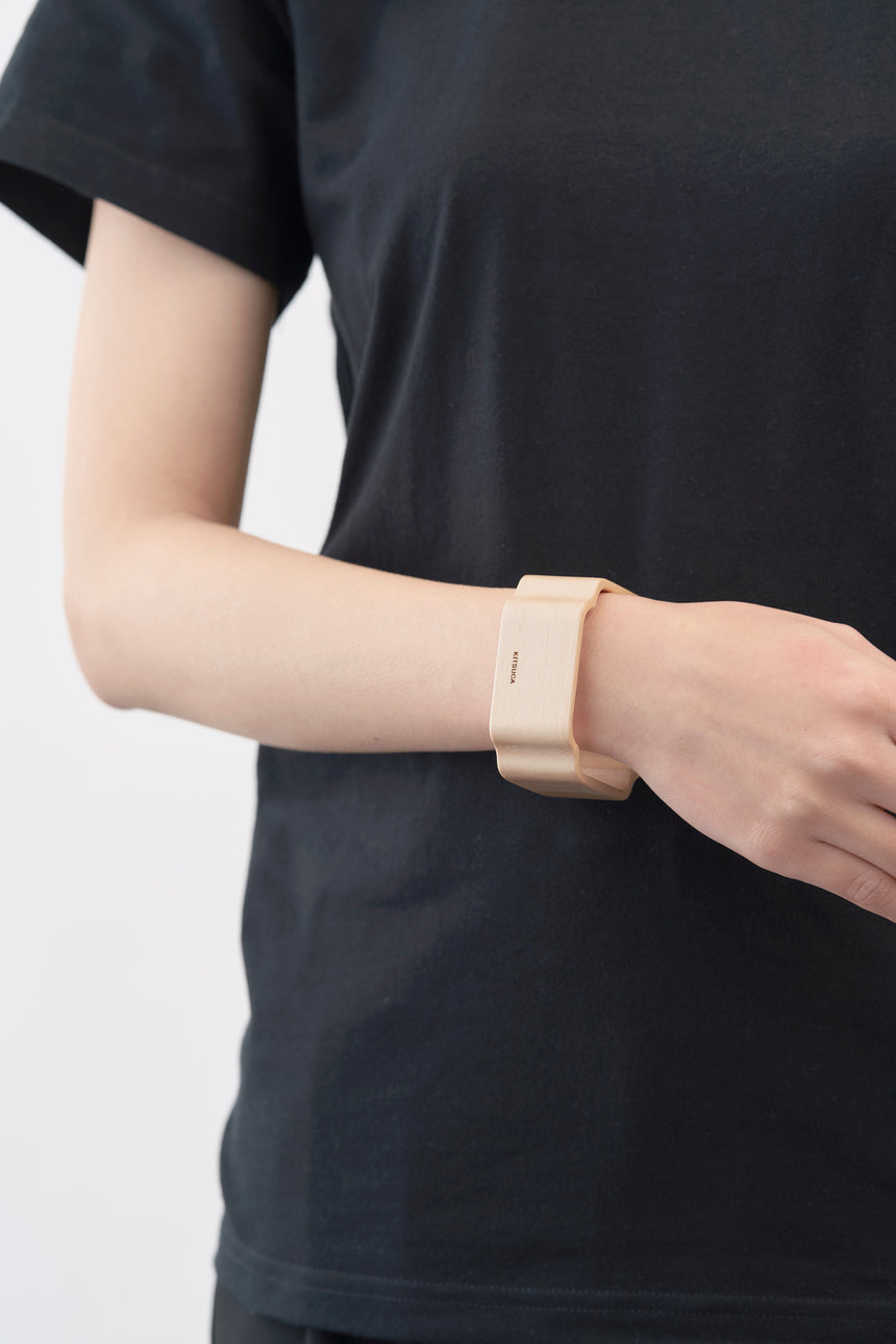 木瓜紋をモチーフにした木製バングルをしたモデル。